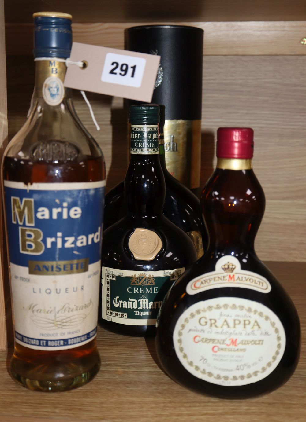 A bottle of Glenfiddich, a bottle of Grappa, a bottle of Whisky Almateo liqueur, a bottle of Grand Marnier and a bottle of Marie Brizar